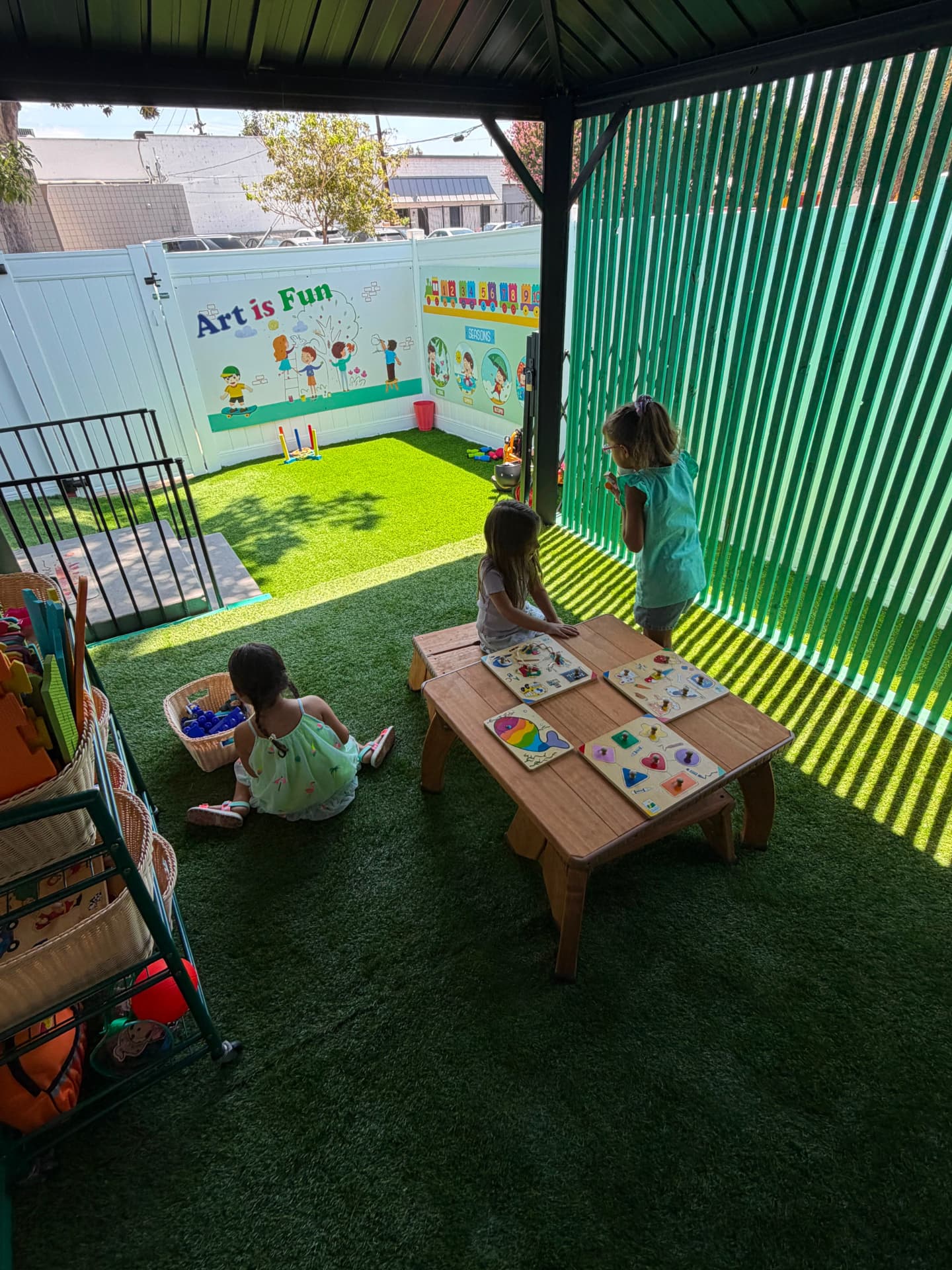 Children playing with learning activities in the covered outdoor area